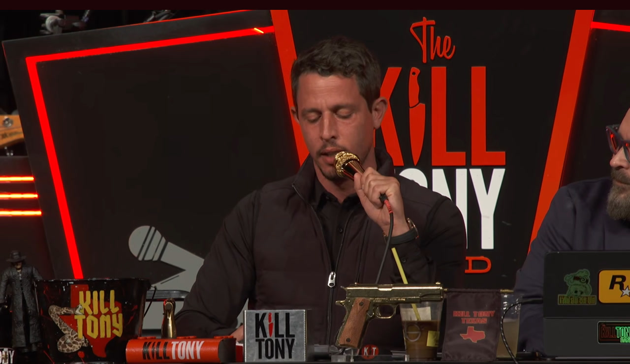 Tony Hinchcliffe at the Kill Tony desk with the gold microphone, Intuit Dome, episode 780.